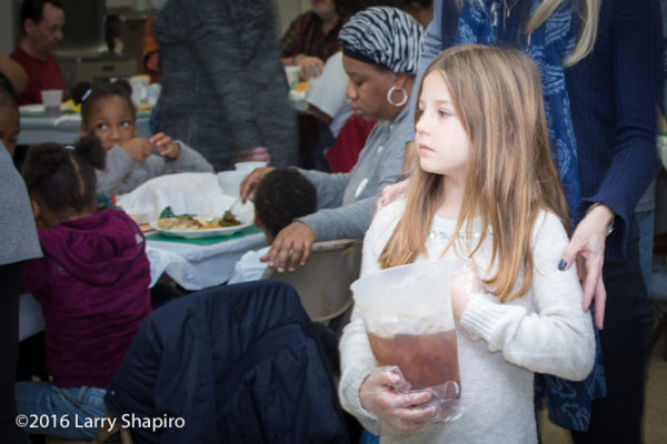 young volunteer serves Thanksgiving dinner