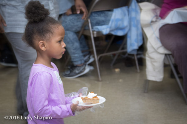 young volunteer serves Thanksgiving dinner