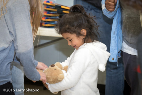 young girl receives a teddy bear on Thanksgiving