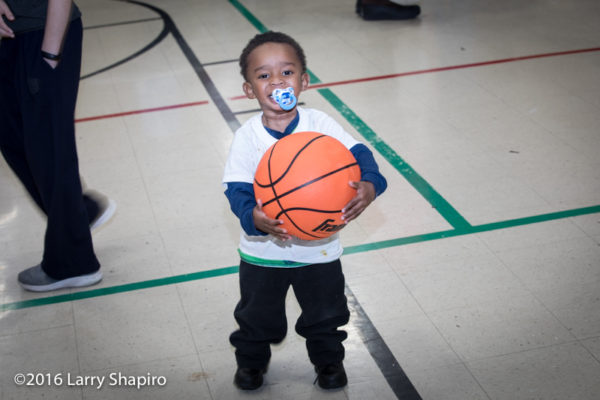 young boy with large basketball
