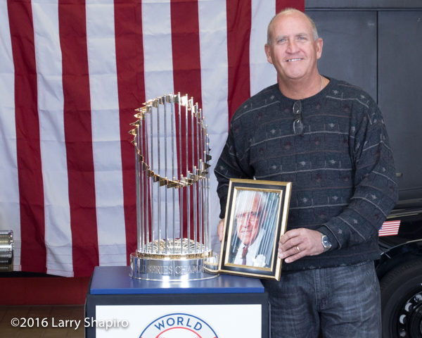 man with photo of deceased father posing with the world series championship trophy