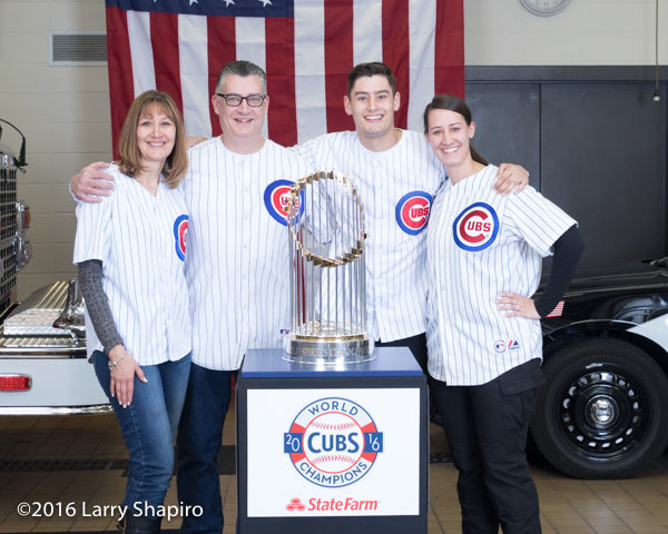 Cub fans posing with the world series championship trophy