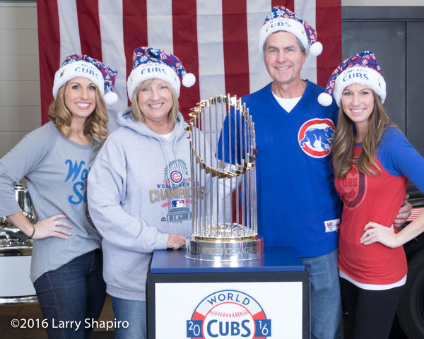family posing with the world series trophy