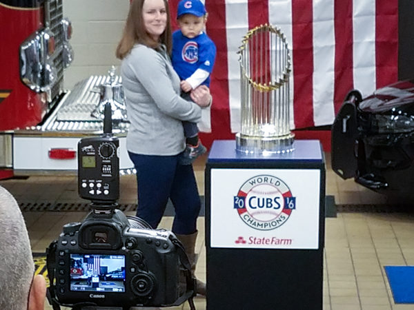 photo being taken of a mother and toddler with the World Series championship trophy