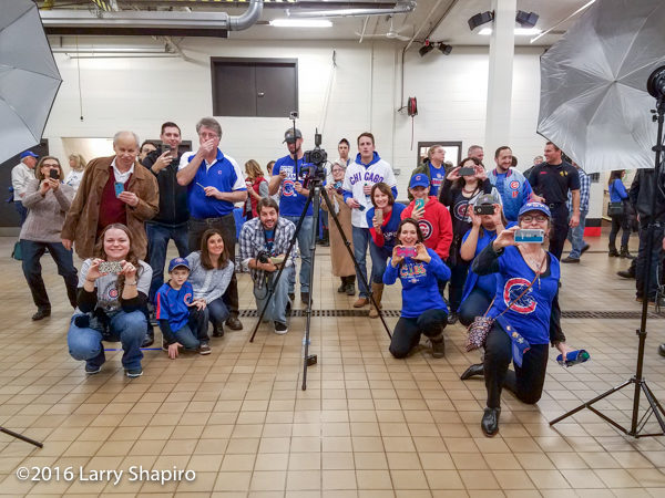 dozens with cell phones taking photos of the World Series championship trophy