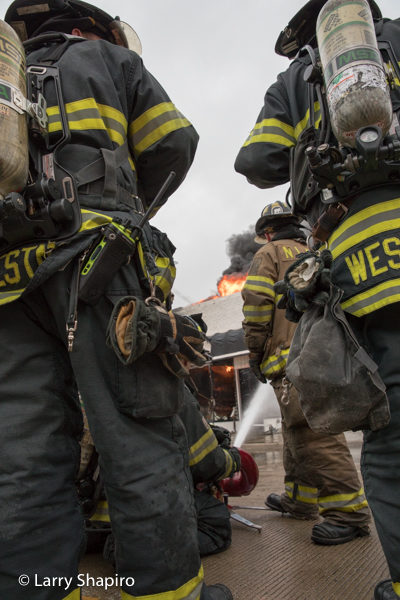 Firefighters standing by at a building fire