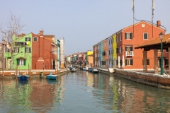 colorful homes line a canal on Burano